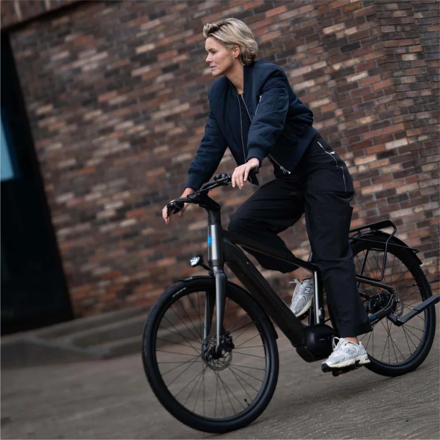 Blonde vrouw fietsend op donkergrijze Levante E4 e-bike