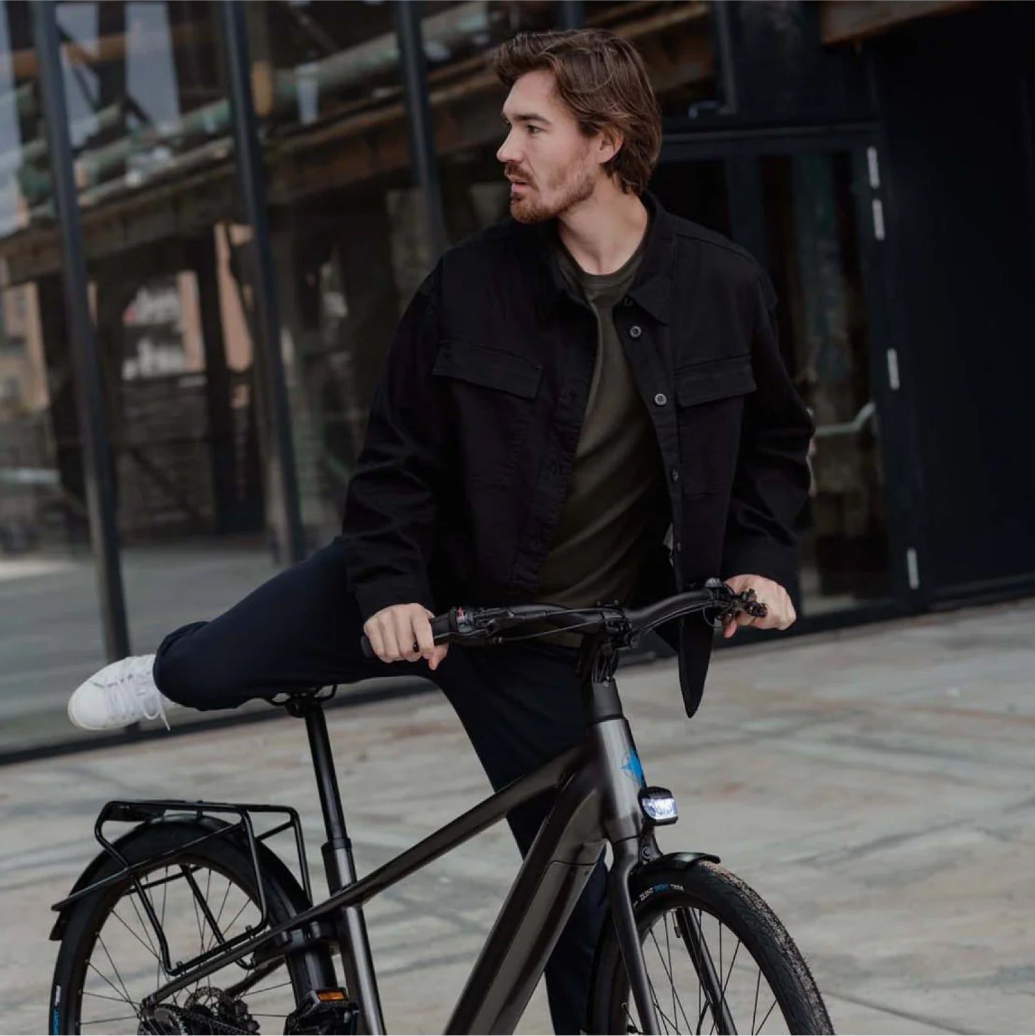 Man die opstapt op donkergrijze Levante E4 e-bike voor industriele gebouwen
