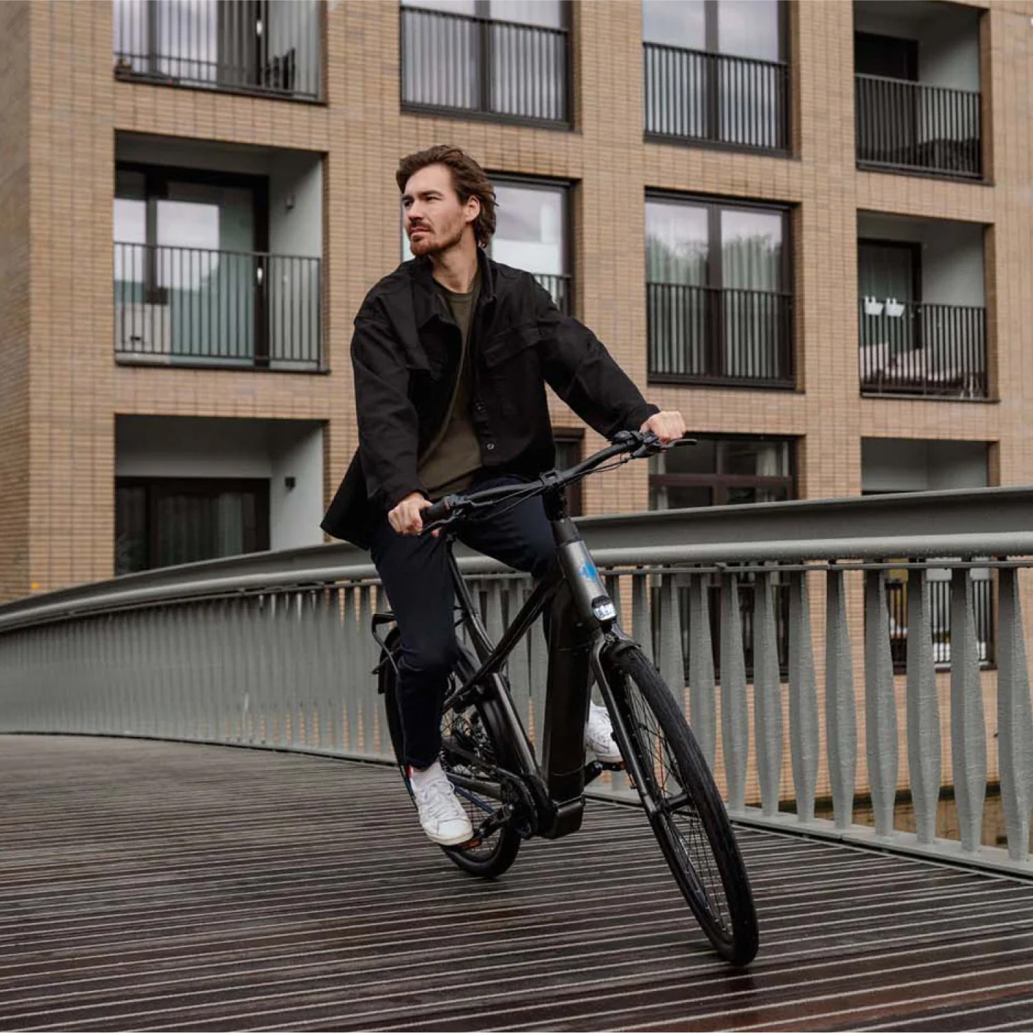 Man fietsend over brug op donkergrijze Levante E4 e-bike