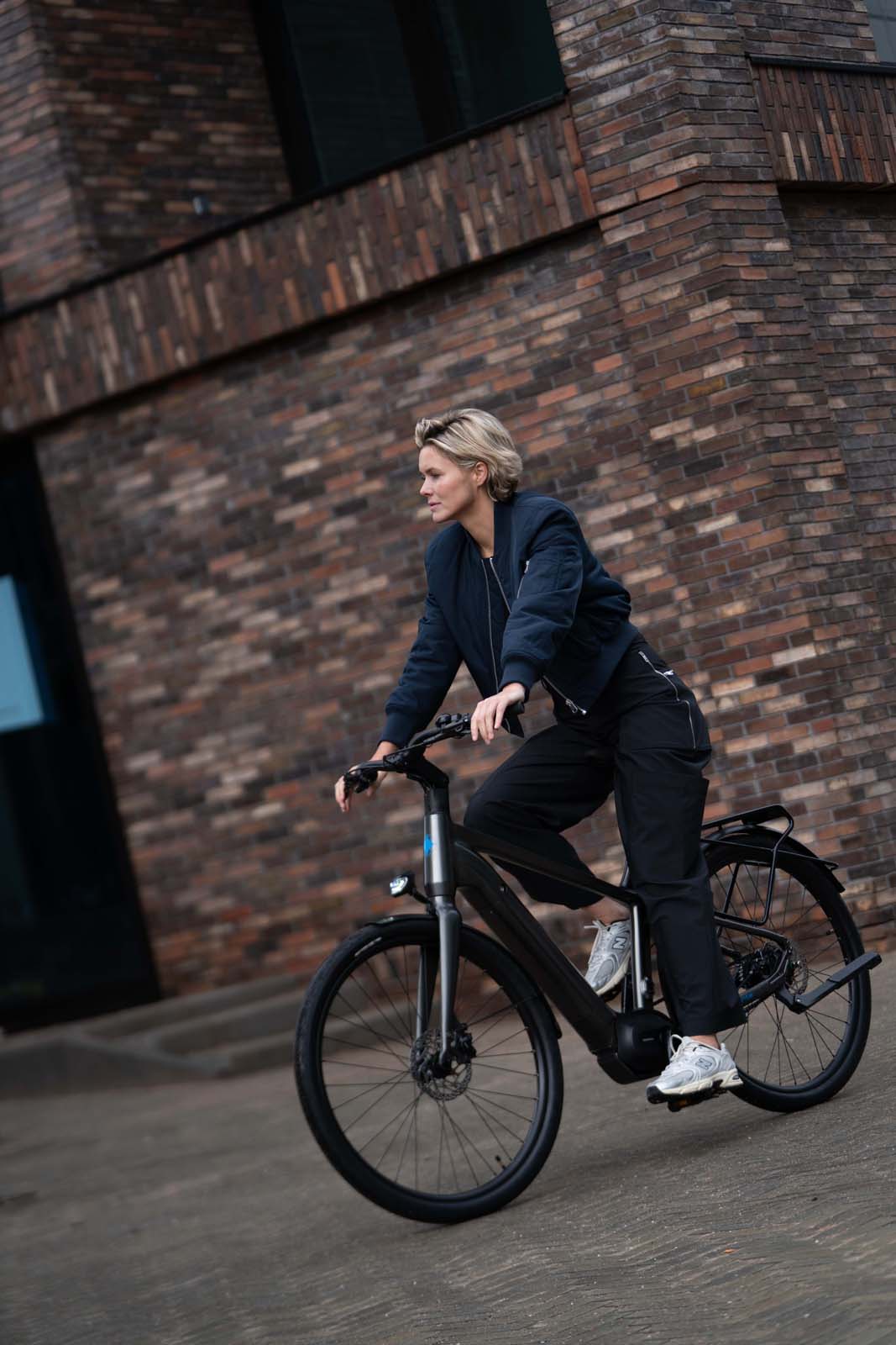Vrouw op Levante E4 e-bike voor stenen muur